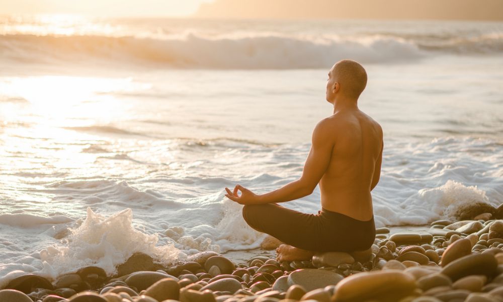 Person meditating near the ocean at sunrise symbolizing mindfulness and inner purpose